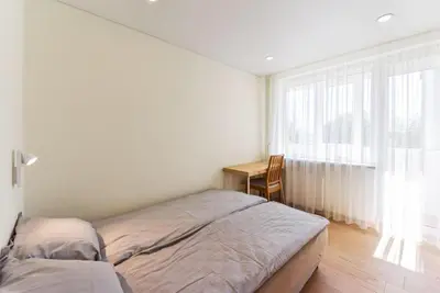 a bedroom with a bed and a desk and a window at Crystal Apartment in Druskininkai