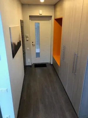 a hallway of an office with a door and wooden floors at Poilsio apartamentai 