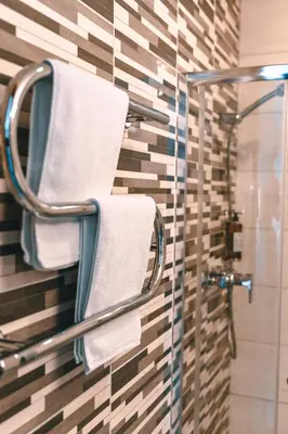 a bathroom with towels on a glass shower stall at Brother House Kaunas in Kaunas