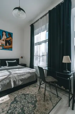 a bedroom with a bed and a desk and a window at Brother House Kaunas in Kaunas