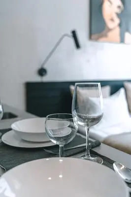a table with a plate and two wine glasses on it at Brother House Kaunas in Kaunas