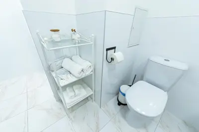a white bathroom with a toilet and towels at Romantic apartment close to the Old Town in Vilnius