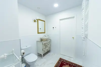 a white bathroom with a toilet and a sink at Romantic apartment close to the Old Town in Vilnius
