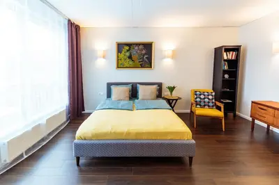a bedroom with a bed and a chair and a window at Romantic apartment close to the Old Town in Vilnius