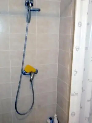 a shower with a yellow sponge in a bathroom at Kambarių nuoma - Rumšiškės SAURIDA in Rumšiškės