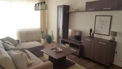 a living room with a couch and a tv at Gardino Apartamentai in Šiauliai