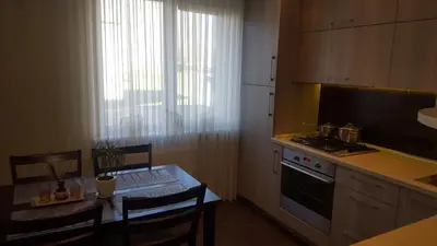 a kitchen with a table and a kitchen with a stove at Gardino Apartamentai in Šiauliai
