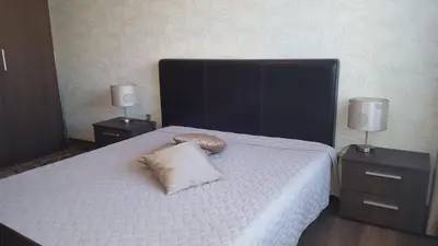 a bedroom with a bed with a pillow and two night stands at Gardino Apartamentai in Šiauliai