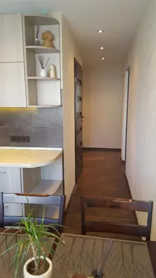 a living room with a table and a chair at Gardino Apartamentai in Šiauliai