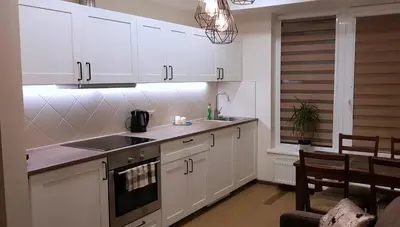 a kitchen with white cabinets and a stove top oven at Barbora apartament in Druskininkai