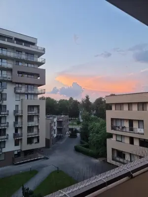 a rainbow in the sky over a city with buildings at Barbora apartament in Druskininkai