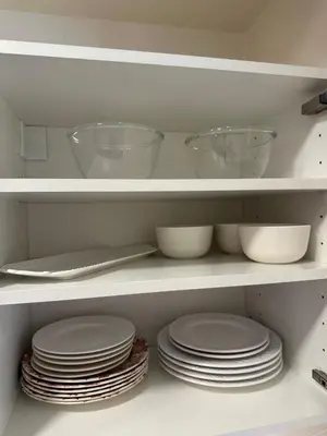 a bunch of plates and bowls on shelves in a kitchen at Barbora apartament in Druskininkai