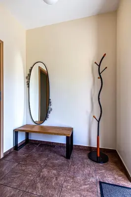 a mirror and a bench in a room at Aušra in Druskininkai