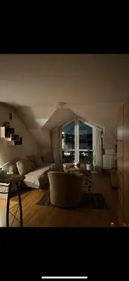 a living room with a bed and a large window at Velux in Vilnius