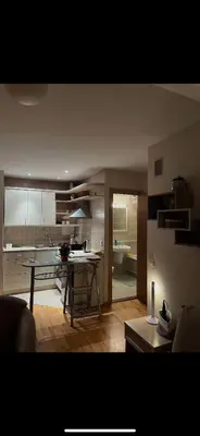 a living room with a table and a kitchen at Velux in Vilnius