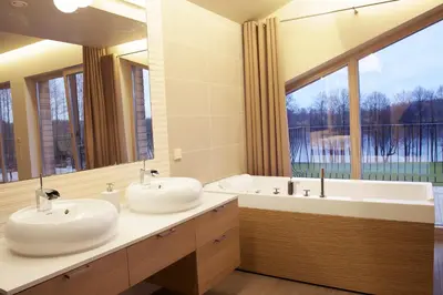 two sinks in a bathroom with a large window at Ami Residence in Druskininkai