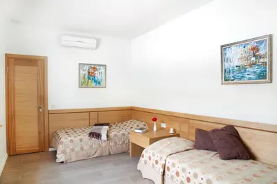 a hotel room with two beds and a table at Ami Residence in Druskininkai