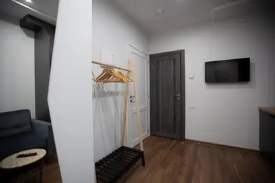 a living room with a couch and a television on a wall at Oak house apartments in Kaunas