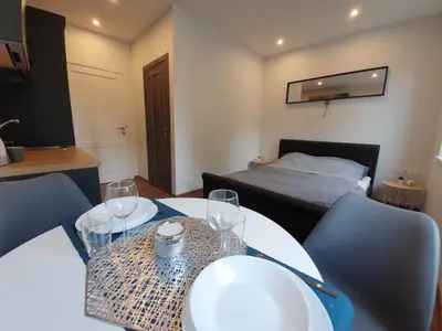 a room with a table and chairs and a bed at Oak house apartments in Kaunas