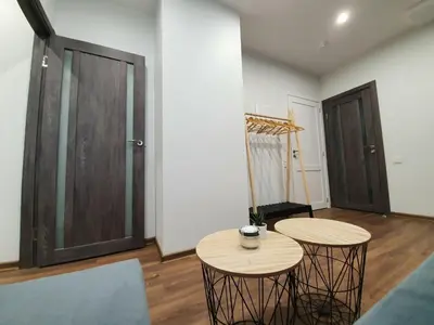 a living room with two tables and a door at Oak house apartments in Kaunas
