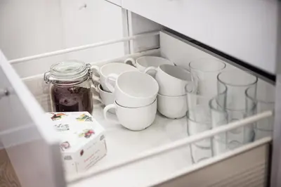 a drawer filled with cups and jars in a refrigerator at Cozy Naugarduko Apartments Close to Vilnius Old Town in Vilnius