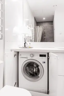 a washing machine in a white bathroom with a mirror at Cozy Naugarduko Apartments Close to Vilnius Old Town in Vilnius