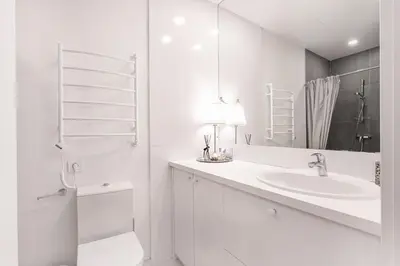 a white bathroom with a sink and a mirror at Cozy Naugarduko Apartments Close to Vilnius Old Town in Vilnius