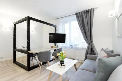 a living room with a desk and a couch at Cozy Naugarduko Apartments Close to Vilnius Old Town in Vilnius