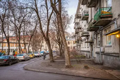 a street with cars parked on the side of the road at Cozy Naugarduko Apartments Close to Vilnius Old Town in Vilnius