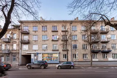 a large brick building with cars parked in front of it at Cozy Naugarduko Apartments Close to Vilnius Old Town in Vilnius