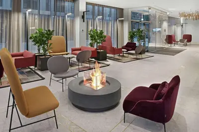 a lobby with chairs and a fire place in the middle at Hilton Garden Inn Vilnius City Centre in Vilnius