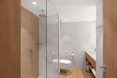 a bathroom with a toilet and a glass shower at Hilton Garden Inn Vilnius City Centre in Vilnius
