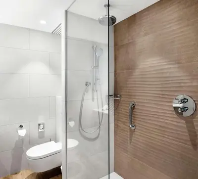 a bathroom with a shower with a toilet and a sink at Hilton Garden Inn Vilnius City Centre in Vilnius