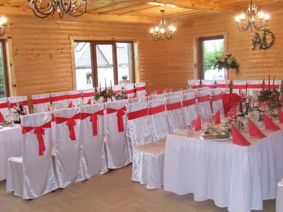 a banquet hall with white tables and red chairs at Country Houses Vidų Sodyba in Utena