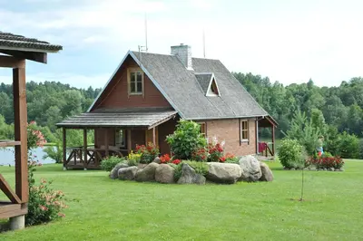 a small house with rocks in front of it at Country Houses Vidų Sodyba in Utena