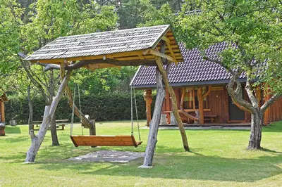 a swing in a park with a house at Sodyba Latkrantė, Druskininkai in Latežeris