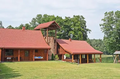 two houses with red roofs on a grass field at Sodyba Latkrantė, Druskininkai in Latežeris