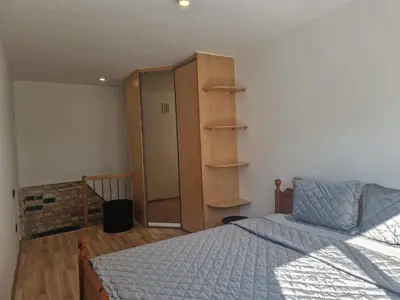 a bedroom with a bed and a dresser and a closet at VK Duplex Apartment in Druskininkai