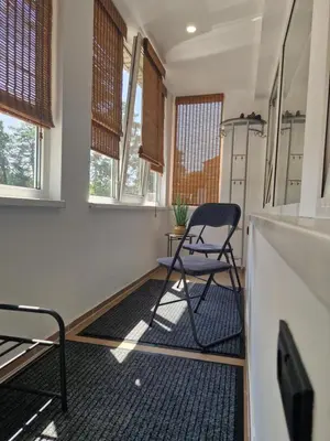 a kitchen with a chair in a room with windows at VK Duplex Apartment in Druskininkai