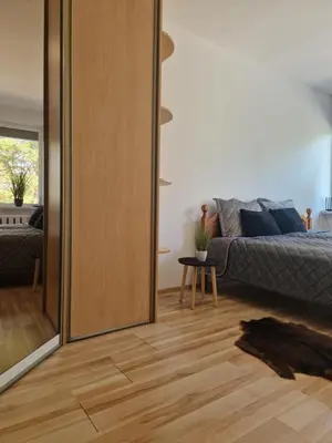 a living room with a bed and a sliding door at VK Duplex Apartment in Druskininkai