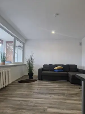 a living room with a couch and a window at VK Duplex Apartment in Druskininkai