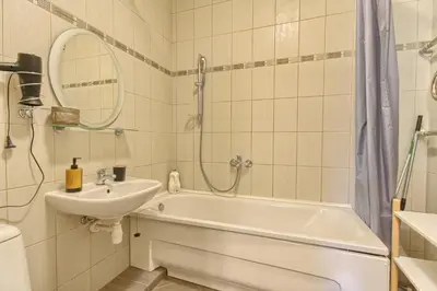a bathroom with a tub and a sink and a mirror at Akva Apartament 1 in Druskininkai