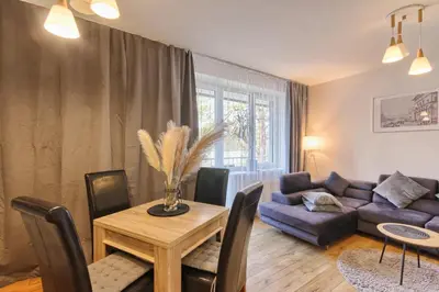 a living room with a table and a couch at Akva Apartament 1 in Druskininkai