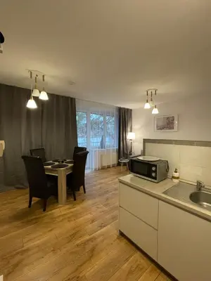 a kitchen and dining room with a table and chairs at Akva Apartament 1 in Druskininkai