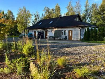 a house with a black roof and a gravel yard at Residence R&R in Karvys