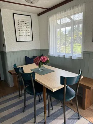 a dining room table with chairs and a vase of flowers on it at Residence R&R in Karvys