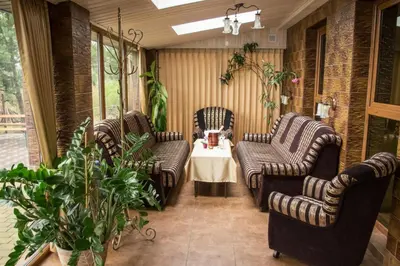 a porch with three chairs and a table in a room at Greta in Druskininkai