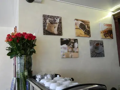 a bathroom with a sink with cups and a vase of roses at Greta in Druskininkai