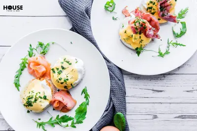 two plates of food with eggs and vegetables on a table at Greta in Druskininkai