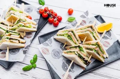 three sandwiches on a plate on a table at Greta in Druskininkai